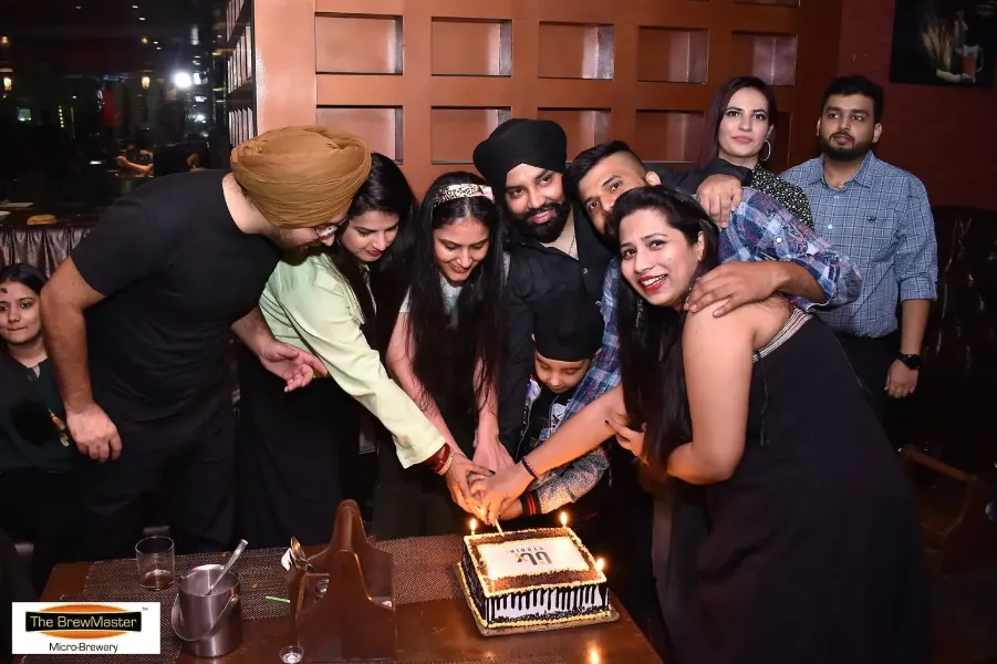 UIUX Studio team cutting a cake at a celebration